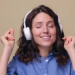 Portrait of millennial woman dance listen music in headphones with closed eyes isolated studio shot